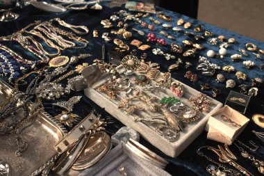 Antiques on flea market or festival - vintage jewelry, silver brooches and other vintage things. Collectibles memorabilia and garage sale concept. Selective focus clipart