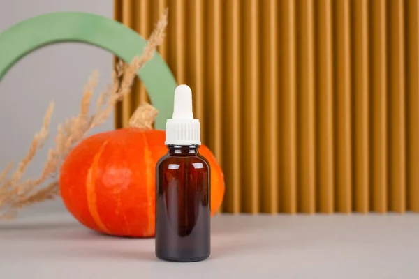 Composición de bodegón con cuentagotas de cosméticos orgánicos naturales: extracto de aceite de semilla de calabaza para el cuidado de la piel o el cabello con calabazas y modelos de yeso. Tratamiento de belleza, concepto de cosmética natural —  Fotos de Stock