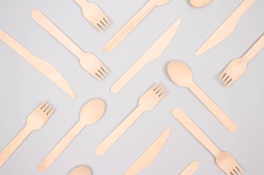 Doğal bambudan yapılmış tek kullanımlık ahşap çatal bıçak seti. Gri arka planda biyolojik olarak bozunabilir gübrelenebilir gübreleme konsepti. Model görüntü. Sıfır atık ve çevresel koruma kavramı. Seçici odak