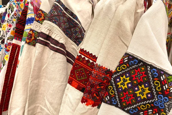 Different Ukrainian vintage clothes - traditional embroidered shirts, vyshyvanka. Secondhand goods on flea market, thrift shopping concept — Stock Photo, Image