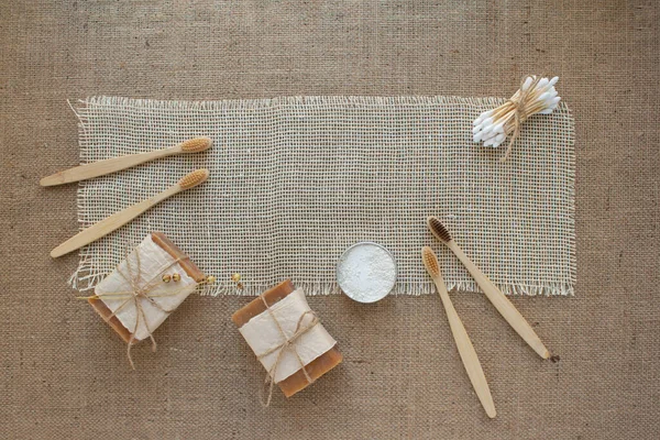 Doğal banyo aletleri, sürdürülebilir sıfır atık ve yaşam tarzı konsepti. Tahta diş fırçaları, bambu çubukları, sabun, arkaplanda kopya alanı olan diş tozu, maket. Seçici odak