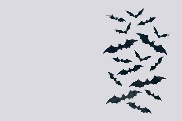 Fundo de Halloween - morcegos de papel preto decorativos em fundo cinza claro com espaço de cópia para texto. Decorações de Halloween ou conceito de convite de festa. Foco seletivo — Fotografia de Stock