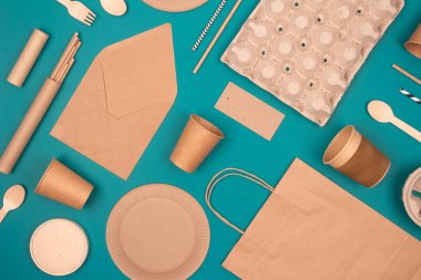 Çevre dostu sofra takımı ve sürdürülebilir ambalajla yatıyordu. Yeşil arka planda Kraft kağıt gıda ambalajı. Sokak yiyecekleri ambalajı, geri dönüşümlü kağıt takımı, sıfır atık ambalaj kavramı