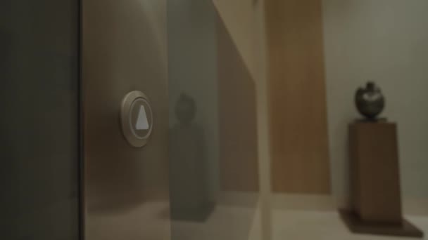 Γυναικείο χέρι πιέζοντας το κουμπί του ανελκυστήρα στο γραφείο κέντρο ή το ξενοδοχείο. Νεαρή γυναίκα που πατάει το κουμπί ανύψωσης. Το δάχτυλο πατάει το κουμπί με το βέλος στραμμένο προς τα πάνω. Κοντινό πλάνο. 4K — Αρχείο Βίντεο