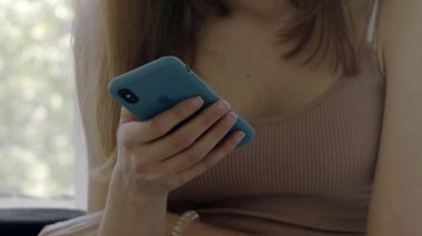 15 Ağustos 2018. Yakın plan. Kız elinde mavi bir çantada iPhone tutuyor ve üzerine bastırıyor. Editör belgeseli.