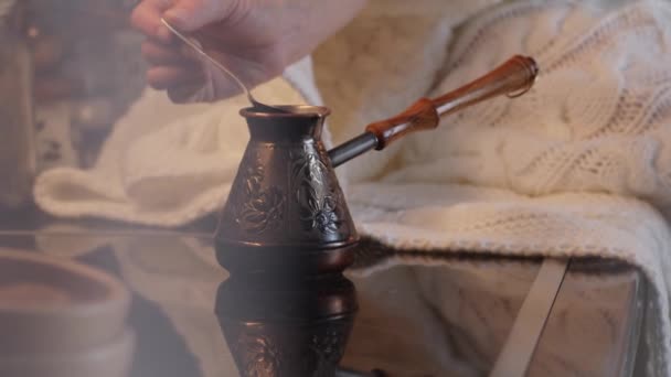 Close-up. A menina de café mexendo com colher de metal durante a fabricação de cerveja em panela de café turca tradicional. Processo de fabricação de café. Câmera manual. — Vídeo de Stock