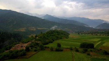 İnanılmaz bir manzara, Gürcistan dağlarındaki yeşil alanlar üzerinde insansız hava aracı uçuşu. Doğanın güzel manzaraları. Yağmurlu hava ve sisli gün.