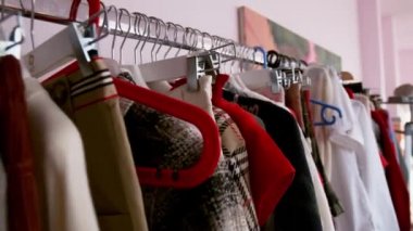 Mağazadaki askılarda farklı kıyafetler var..