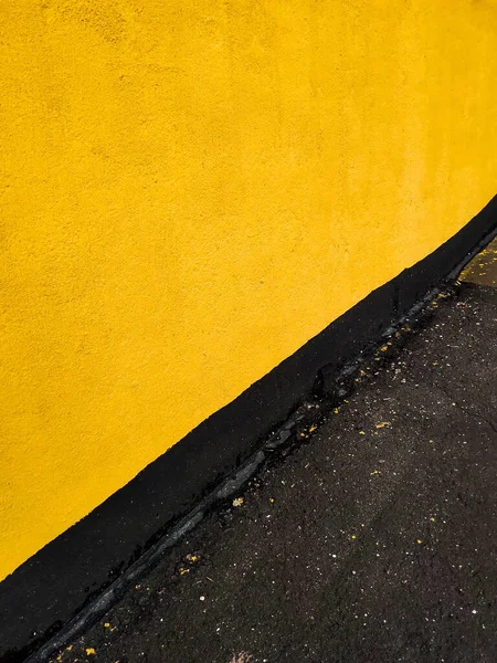 Желтая стена дома и черный асфальт. Заставка на рабочем столе. — стоковое фото