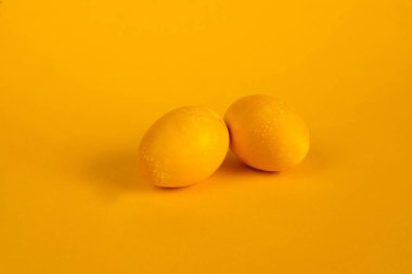 Sarı arka planda iki sarı yumurta. Parlak Paskalya Bayramı.
