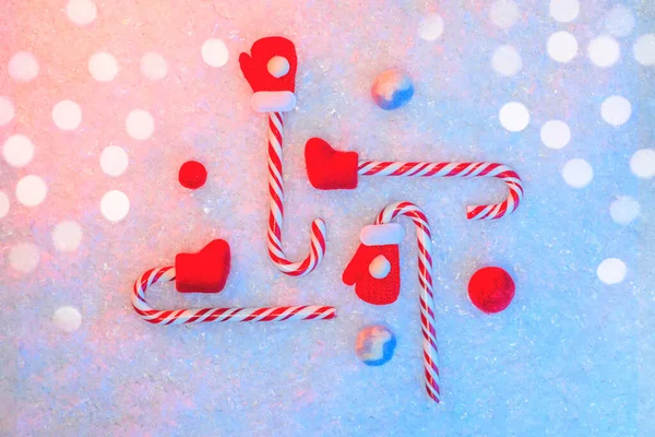 Año Nuevo flatlay en la nieve con caramelos rojos, manoplas, botas de fieltro y bolas de nieve, concepto de Navidad — Foto de Stock