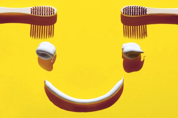 Drewniane Szczoteczki Zębów Makaron Żółtym Tle Koncepcja Stomatologiczna Postaci Śmiesznej — Zdjęcie stockowe