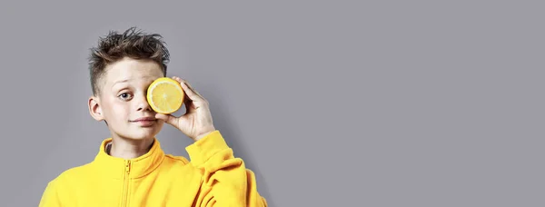 Menino Uma Jaqueta Amarela Brilhante Com Limão Mão Sobre Fundo — Fotografia de Stock