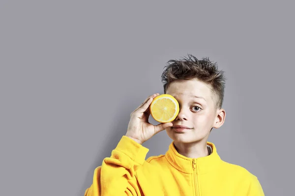 Niño Con Una Chaqueta Color Amarillo Brillante Con Limón Mano — Foto de Stock