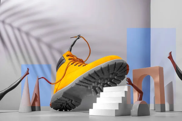 鞋的概念 楼梯上的黄色靴子 女人的腿和手 灰色背景上的棕榈色 拱形和其他几何形状 2021年色彩 — 图库照片