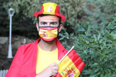 İspanya bayrağı ve sağlık maskesi takmış yakışıklı genç bir adamın portresi.