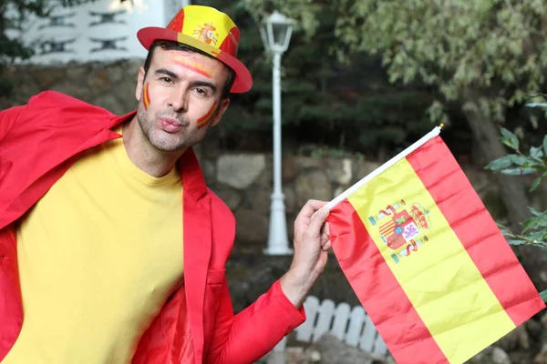 portrait of handsome young man in clothes colored in Spain flag on nature