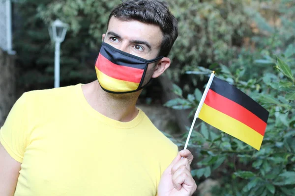 Retrato Jovem Bonito Alemão Máscara Respiração Colorida Segurando Bandeira Alemã — Fotografia de Stock