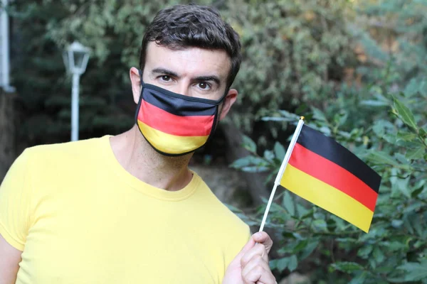 Retrato Jovem Bonito Alemão Máscara Respiração Colorida Segurando Bandeira Alemã — Fotografia de Stock