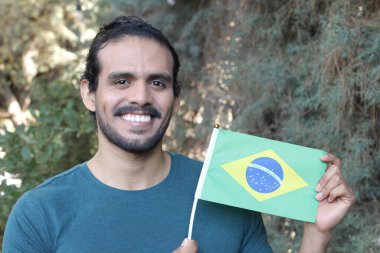 Park yerinde bayrağı olan yakışıklı bir gencin portresi.