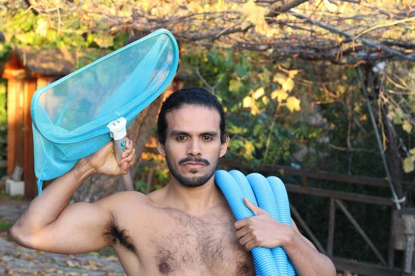 口ひげと長い髪を持つハンサムな若い男のクローズアップポートレートプール掃除のためのネットとパイプ — ストック写真