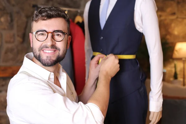 portrait of handsome youth fashion designer in his workshop