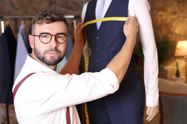 portrait of handsome youth fashion designer in his workshop