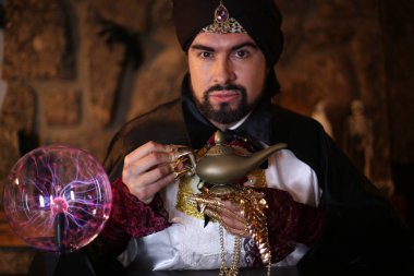 Sihirli lambayla sakallı müslüman adamın yakın plan portresi.