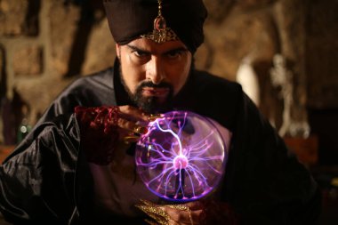 Sihirli giysiler içinde gizemli lamba tutan Müslüman sakallı adamın yakın plan portresi.