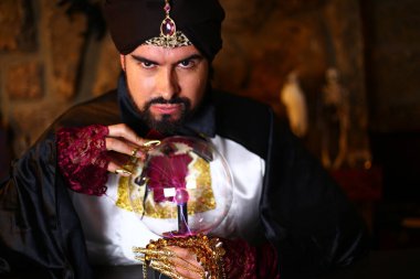 Sihirli giysiler içinde gizemli lamba tutan Müslüman sakallı adamın yakın plan portresi.