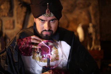 Sihirli giysiler içinde gizemli lamba tutan Müslüman sakallı adamın yakın plan portresi.