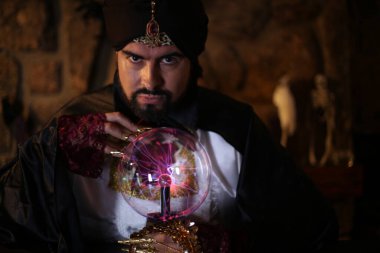 Sihirli giysiler içinde gizemli lamba tutan Müslüman sakallı adamın yakın plan portresi.