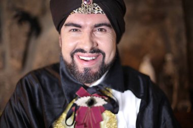 Sihirbaz kıyafetleri içindeki Müslüman sakallı adamın yakın plan portresi.