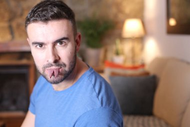 Kırık dilli yakışıklı bir gencin portresi. Kameraya bakıyor.