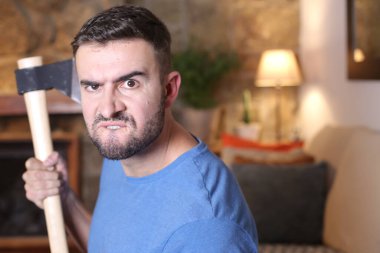 Evinde baltasını tutan yakışıklı bir gencin portresi.