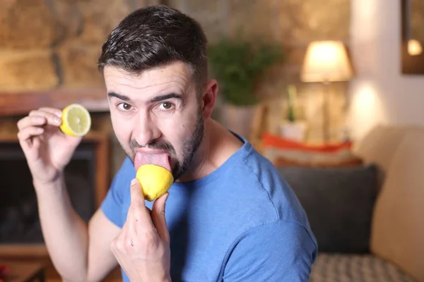 ハンサムな若い男の肖像画家でサワーレモンフルーツを舐める — ストック写真