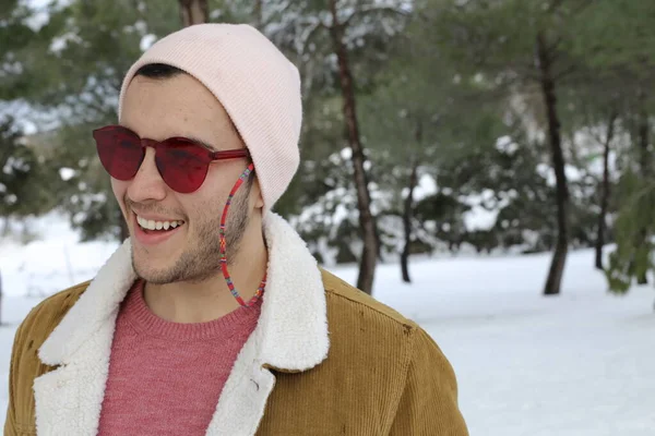 スタイリッシュな暖かい服を着たハンサムな若い男と冬の森の赤いサングラス — ストック写真