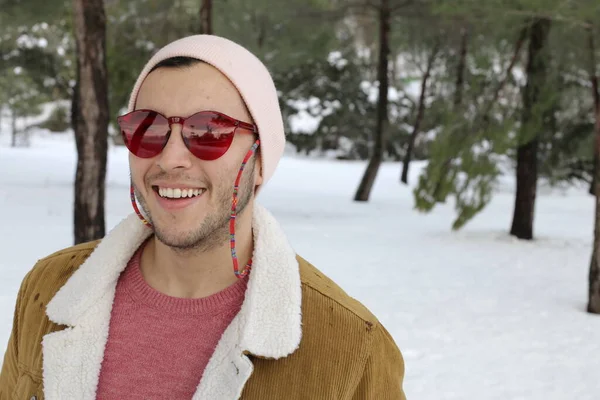 スタイリッシュな暖かい服を着たハンサムな若い男と冬の森の赤いサングラス — ストック写真