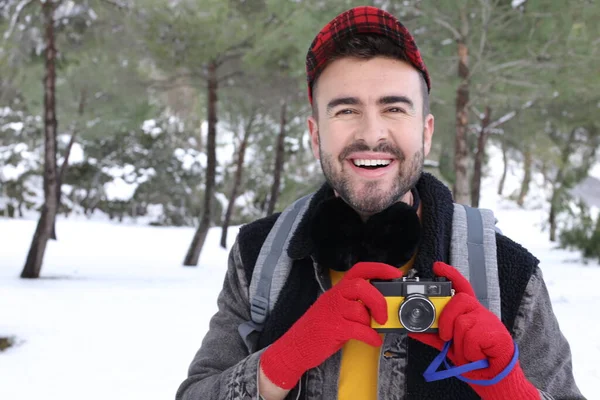 年轻英俊男子背着背包 在冬季森林里拿着老式胶卷相机 — 图库照片