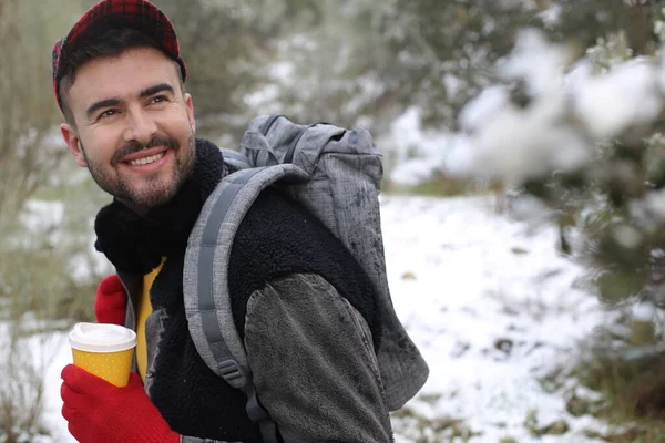 Stilig Ung Man Med Ryggsäck Och Pappersmugg Kaffe Vinterskogen — Stockfoto