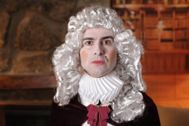 Viktorya tarzı kostümlü genç adam içeride poz veriyor.