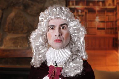 Viktorya tarzı kostümlü genç adam içeride poz veriyor.