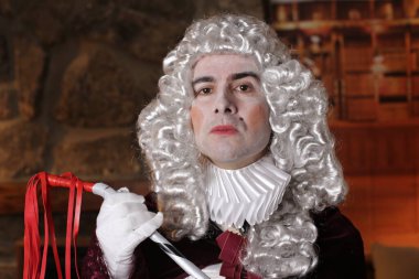 Viktorya tarzı kostümlü genç adam içeride poz veriyor.