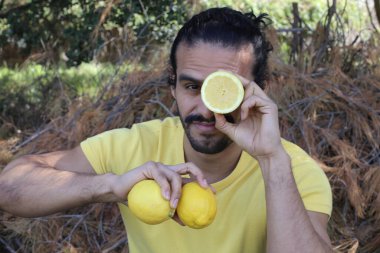 Açık havada limonlu sarı tişörtlü yakışıklı genç adamın portresi.