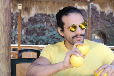 Açık havada limonlu sarı tişörtlü yakışıklı genç adamın portresi.