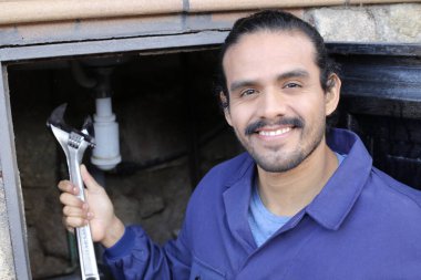 İngiliz anahtarı olan yakışıklı bir tesisatçının portresi.