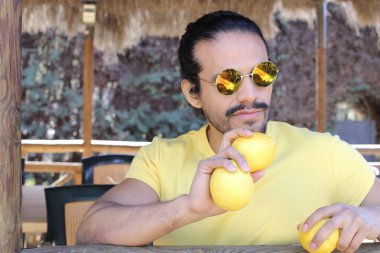 Açık havada limonlu sarı tişörtlü yakışıklı genç adamın portresi.