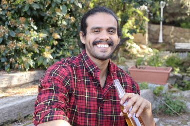 Dışarıda bira şişesi olan yakışıklı bir gencin portresi.