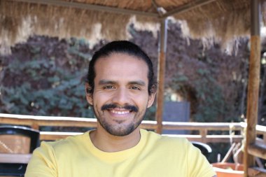 Dışarıdaki sarı tişörtlü yakışıklı genç adamın portresi.