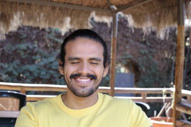 Dışarıdaki sarı tişörtlü yakışıklı genç adamın portresi.